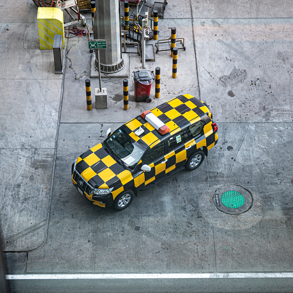 A photo of a black and yellow checkered SUV on the tarmac of an airport