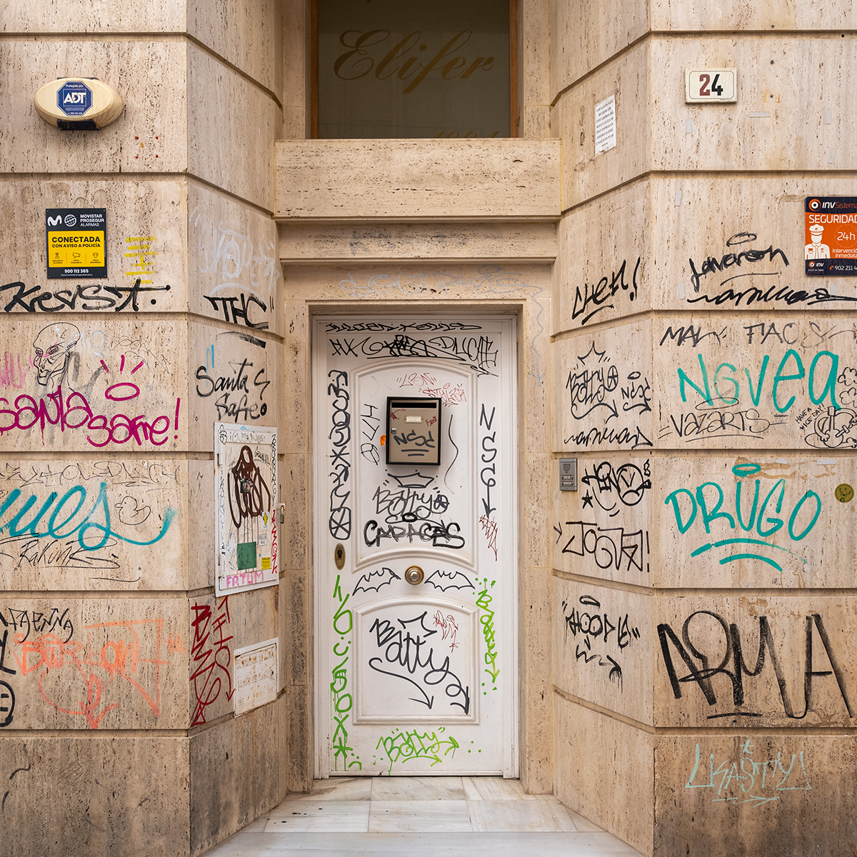 A photo of exterior doorway covered in graffiti
